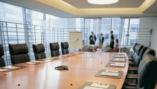 GreerWalker-Feature-Boardroom-table-with-people-in-the-background-777